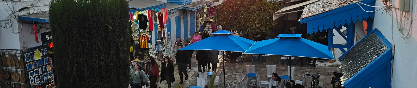 Rue en escalier de Sidi Bou Saïd au coucher du soleil, échoppes et terrasse de café